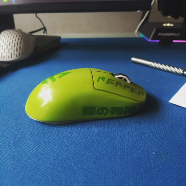 Lime-green gaming mouse with dark lettering on a blue desk mat.