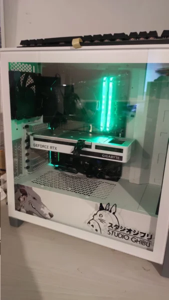 White desktop PC with a glass side panel, green lighting, and illustrated decals.