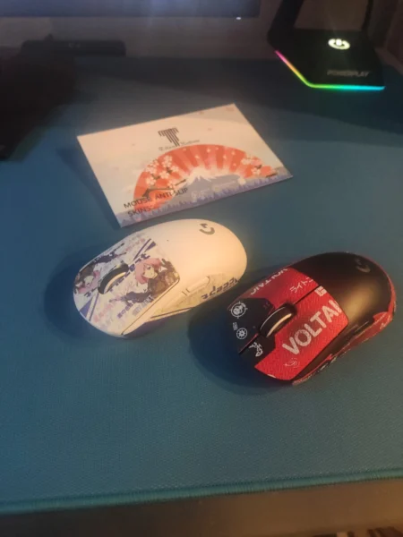 Two gaming mice with illustrated white and red grip skins on a blue desk mat.